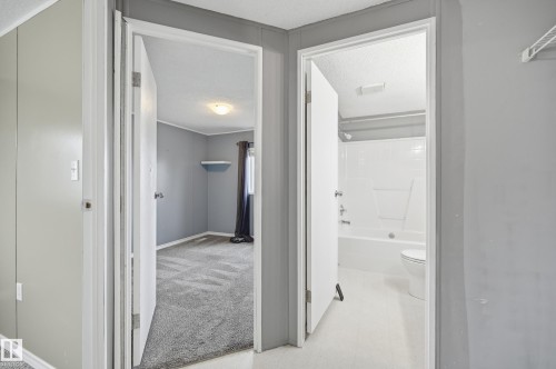 Interior hallway featuring light gray walls, white trim, and a white interior door - 106 Springfield Crescent, Spruce Grove, AB - Indoor Photo Showing Other Room