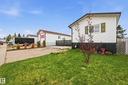 White vinyl siding exterior with olive green window shutters and a dark skirting - 106 Springfield Crescent, Spruce Grove, AB - Outdoor