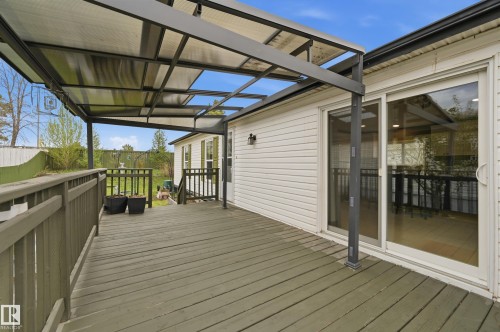 Spacious outdoor deck featuring a protective patio cover and a sliding glass door entry to the interior - 106 Springfield Crescent, Spruce Grove, AB - Outdoor With Deck Patio Veranda With Exterior