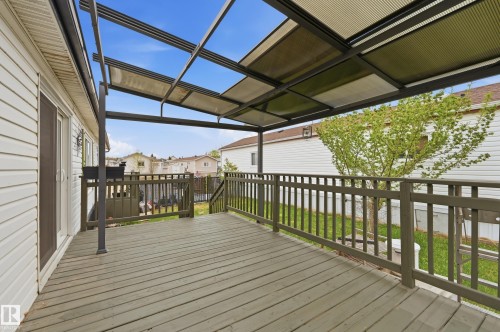 Spacious outdoor deck featuring wood-finish flooring, a metal frame patio cover, and a protective railing - 106 Springfield Crescent, Spruce Grove, AB - Outdoor With Deck Patio Veranda With Exterior
