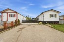 Front exterior featuring white siding with contrasting trim, a gabled roofline, and a paved driveway - 106 Springfield Crescent, Spruce Grove, AB  - Outdoor 
