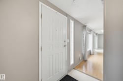 Entryway featuring a paneled door with sidelight windows, light gray wall finishes, and wood-finish flooring - 