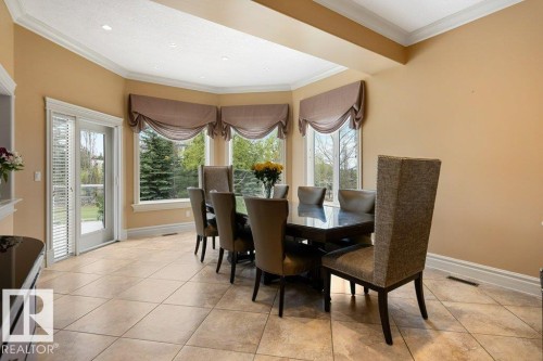 Bay window dining area featuring neutral-toned tile flooring, direct outdoor access via a glass door, crown molding, and recessed lighting - 58 Riverstone Close, Rural Sturgeon County, AB - Indoor Photo Showing Dining Room
