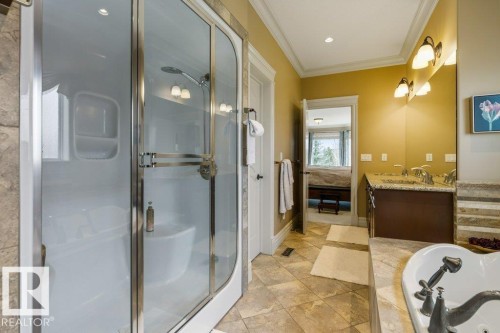 Bathroom featuring a corner glass-enclosed shower with a built-in seat, a dual vanity with a granite countertop, and a jetted soaking tub - 58 Riverstone Close, Rural Sturgeon County, AB - Indoor Photo Showing Bathroom