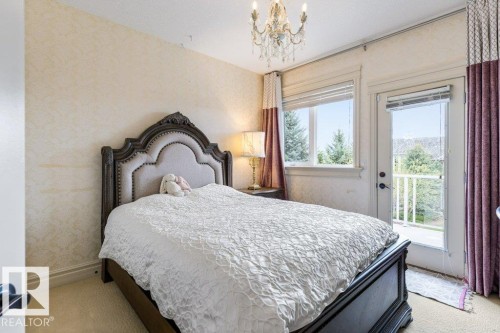 Bedroom featuring direct access to an outdoor balcony, a large window, and wall-to-wall carpeting - 58 Riverstone Close, Rural Sturgeon County, AB - Indoor Photo Showing Bedroom