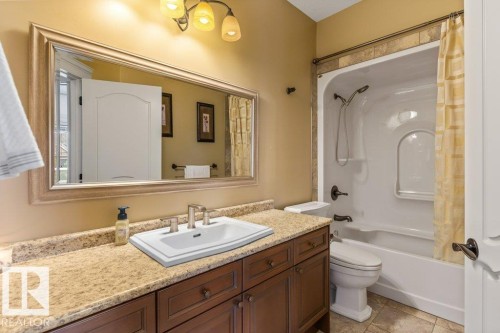 Bathroom featuring a spacious vanity with an undermount sink, a large framed mirror, and a full bathtub with an integrated shower - 58 Riverstone Close, Rural Sturgeon County, AB - Indoor Photo Showing Bathroom