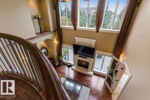 Grand foyer with a curved hardwood staircase featuring wrought iron spindles - 58 Riverstone Close, Rural Sturgeon County, AB - Indoor Photo Showing Other Room