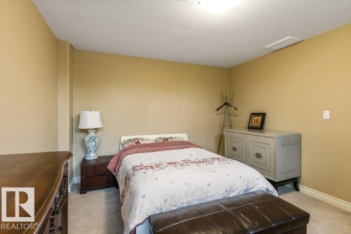 Bedroom featuring wall-to-wall carpeting, neutral wall color, and a textured ceiling - 58 Riverstone Close, Rural Sturgeon County, AB - Indoor Photo Showing Bedroom