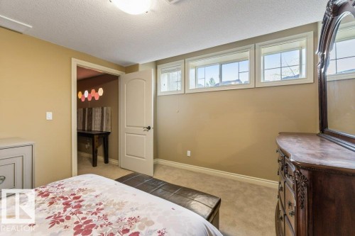 Carpeted room featuring a light-colored wall paint and three horizontal windows - 58 Riverstone Close, Rural Sturgeon County, AB - Indoor Photo Showing Bedroom