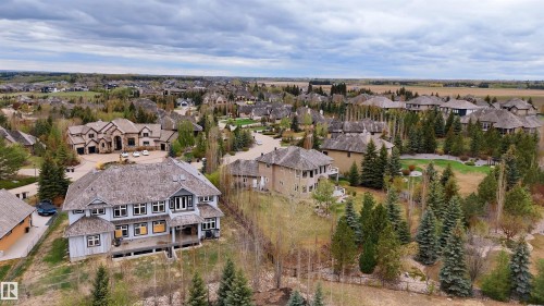 Large residential property featuring a multi-story design with light-colored siding and an expansive shingle roof - 58 Riverstone Close, Rural Sturgeon County, AB - Outdoor With View