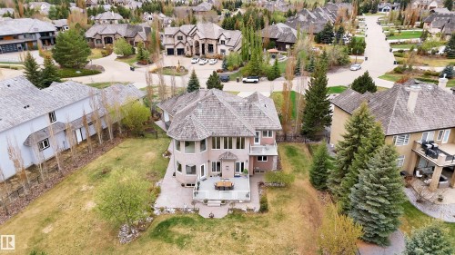 Multi-story residence featuring a private patio, mature trees, and a shingled roof, surrounded by established landscaping - 58 Riverstone Close, Rural Sturgeon County, AB - Outdoor