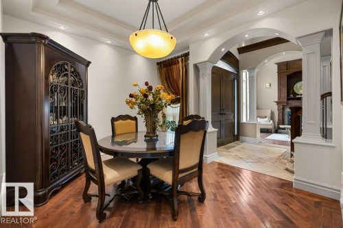 Hardwood-finish flooring complementing a tray ceiling with recessed lighting - 58 Riverstone Close, Rural Sturgeon County, AB - Indoor Photo Showing Dining Room