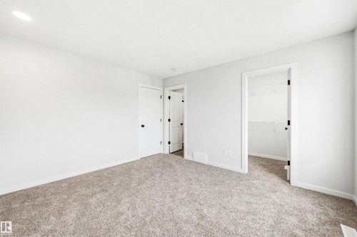 Neutral-toned carpeting paired with white walls, featuring recessed lighting and white trim baseboards - 22429 83A Avenue, Edmonton, AB - Indoor Photo Showing Other Room