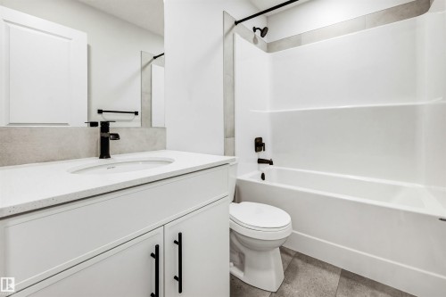 Bathroom featuring a white vanity with a light-toned countertop, an undermount sink, and a matte black faucet - 22429 83A Avenue, Edmonton, AB - Indoor Photo Showing Bathroom