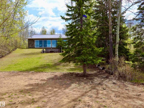 Wood-sided residence featuring a metal roof and a full-width deck - #26 5508 Twp Rd 593A, Rural Barrhead County, AB - Outdoor