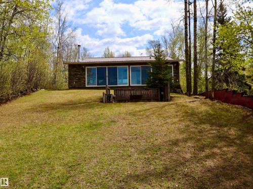 Stone facade home featuring a metal roof and prominent rear-facing windows - #26 5508 Twp Rd 593A, Rural Barrhead County, AB - Outdoor