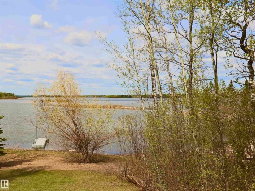 Waterfront property featuring a private dock and mature trees - #26 5508 Twp Rd 593A, Rural Barrhead County, AB - Outdoor With View