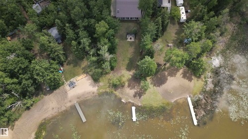 Expansive lakefront property featuring a private sandy beach, multiple docks, and abundant mature trees - #26 5508 Twp Rd 593A, Rural Barrhead County, AB - Outdoor With Body Of Water With View