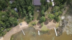 Expansive lakefront property featuring a private sandy beach, multiple docks, and abundant mature trees - 