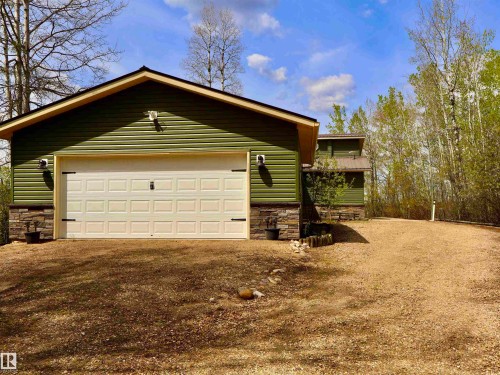 Attached two-car garage featuring a paneled door with decorative hardware - #26 5508 Twp Rd 593A, Rural Barrhead County, AB - Outdoor