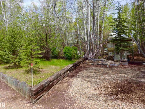 Gravel area bordered by a rustic timber retaining wall - #26 5508 Twp Rd 593A, Rural Barrhead County, AB - Outdoor