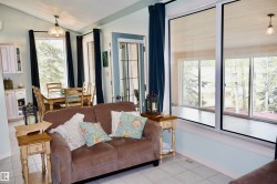Open-concept living area featuring large pane windows and a dining space - 
