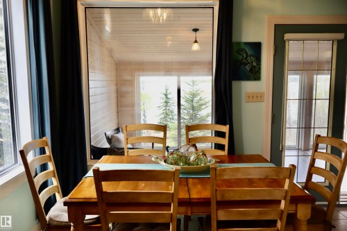 Dining space with a sliding glass door providing access to an enclosed porch - #26 5508 Twp Rd 593A, Rural Barrhead County, AB - Indoor Photo Showing Dining Room