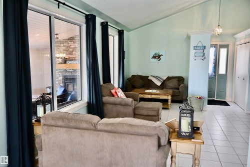 Spacious living area featuring vaulted ceilings, light-toned walls, and tile flooring - #26 5508 Twp Rd 593A, Rural Barrhead County, AB - Indoor Photo Showing Living Room