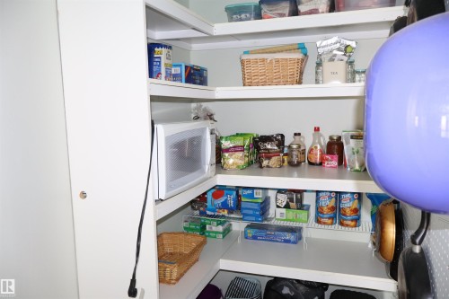 Built-in white shelving system with a corner configuration, offering varied storage options - #26 5508 Twp Rd 593A, Rural Barrhead County, AB - Indoor Photo Showing Other Room