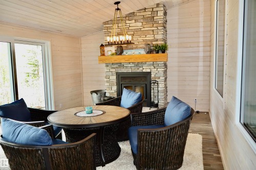 Stone fireplace with a wood mantel - #26 5508 Twp Rd 593A, Rural Barrhead County, AB - Indoor With Fireplace