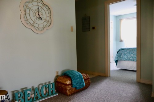 Interior hallway with textured wall-to-wall carpeting and neutral wall paint - #26 5508 Twp Rd 593A, Rural Barrhead County, AB - Indoor