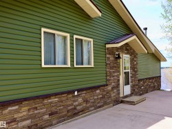 Green horizontal siding exterior with a stacked stone facade - 
