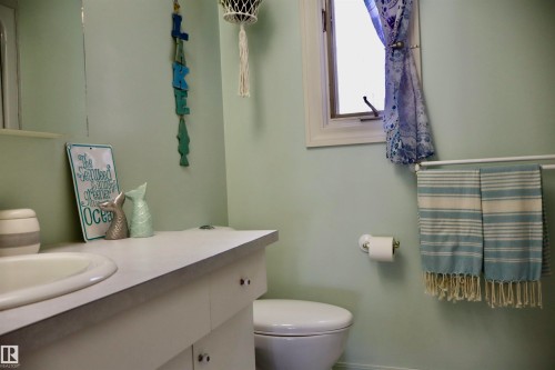 Bathroom featuring a white vanity with an integrated sink, light countertop, and white cabinetry - #26 5508 Twp Rd 593A, Rural Barrhead County, AB - Indoor Photo Showing Bathroom