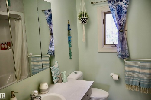 Bathroom featuring a built-in tub with shower, single vanity with integrated sink, and an overhead mirrored medicine cabinet - #26 5508 Twp Rd 593A, Rural Barrhead County, AB - Indoor Photo Showing Bathroom