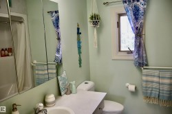 Bathroom featuring a built-in tub with shower, single vanity with integrated sink, and an overhead mirrored medicine cabinet - 