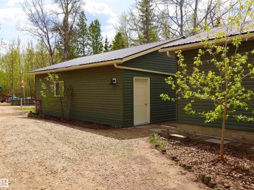 Detached garage with dark green horizontal siding, white trim, and a metal roof - #26 5508 Twp Rd 593A, Rural Barrhead County, AB - Outdoor