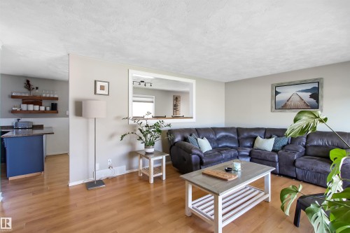 Open-concept living area with wood-finish flooring, light gray wall paint, and a textured white ceiling - 803 12 Avenue, Cold Lake, AB - Indoor Photo Showing Living Room