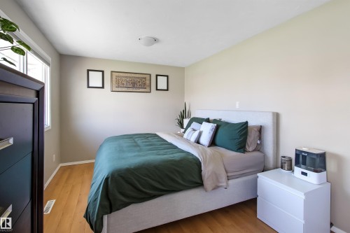 Spacious room with wood-finish flooring, a contemporary flush-mount ceiling light, and light-toned wall paint - 803 12 Avenue, Cold Lake, AB - Indoor Photo Showing Bedroom