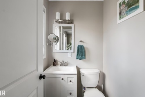 Bathroom vanity with white cabinetry, integrated sink, and chrome faucet - 803 12 Avenue, Cold Lake, AB - Indoor Photo Showing Bathroom