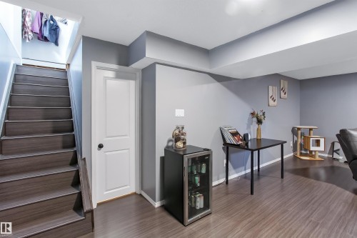 Lower level living area featuring wood-finish flooring, light gray walls, white trim, and a built-in recessed ceiling beam - 803 12 Avenue, Cold Lake, AB - Indoor Photo Showing Other Room