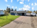 Single-story residence featuring a blue exterior with white trim, a covered front porch, and an attached carport - 803 12 Avenue, Cold Lake, AB  - Outdoor With Facade 