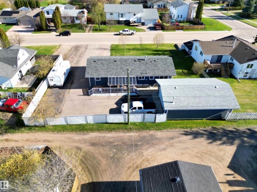 Property featuring a dark gray roof, an attached garage with a light gray roof, and a fenced perimeter - 803 12 Avenue, Cold Lake, AB - Outdoor