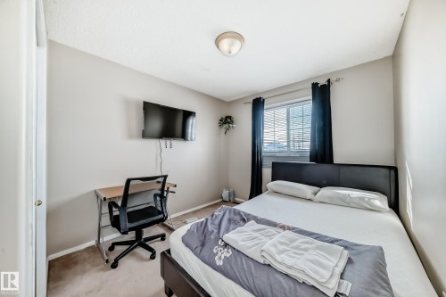Carpeted bedroom with neutral wall paint and a built-in ceiling light fixture - 19024 50 Avenue, Edmonton, AB - Indoor Photo Showing Bedroom