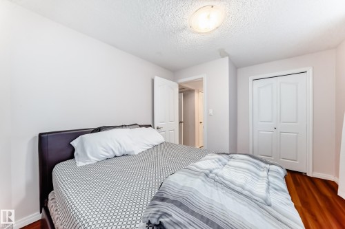 Bedroom featuring wood-finish flooring, a neutral color palette, ceiling-mounted light fixture, and bifold closet doors - 19024 50 Avenue, Edmonton, AB - Indoor Photo Showing Bedroom