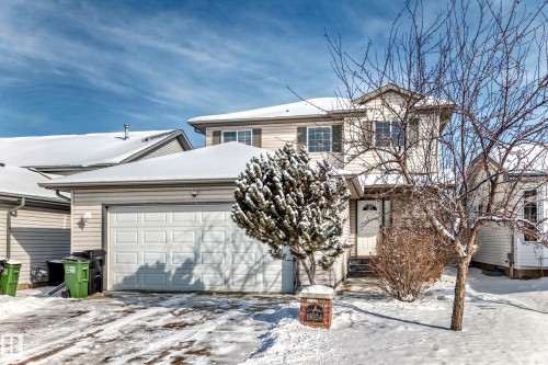 Two-story residence featuring light-colored siding and a two-car garage with a panel door - 19024 50 Avenue, Edmonton, AB - Outdoor