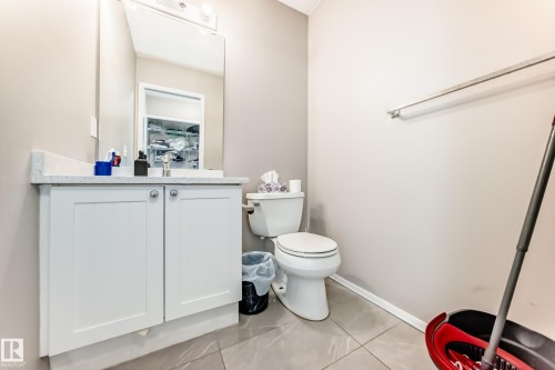 White shaker-style vanity with a light-toned countertop, under-mount sink, and polished chrome faucet - 19024 50 Avenue, Edmonton, AB - Indoor Photo Showing Bathroom