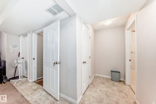 Hallway featuring neutral wall paint, overhead lighting, and two panel doors - 19024 50 Avenue, Edmonton, AB - Indoor Photo Showing Other Room