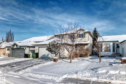 Exterior featuring light-colored siding, a two-car garage, and a snow-covered roof - 19024 50 Avenue, Edmonton, AB - Outdoor