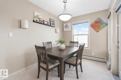 Dining area featuring a central window, carpeted flooring, and a ceiling-mounted light fixture - 