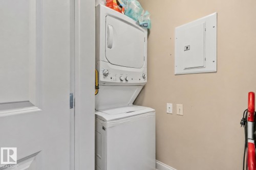 Dedicated laundry area featuring a stacked washer and dryer unit - 206 103 Ambleside Drive, Edmonton, AB - Indoor Photo Showing Laundry Room